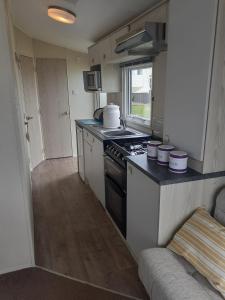 a kitchen with a stove and a counter top at PerranporthCaravan 2bedroom Tv GasFire in Perranporth