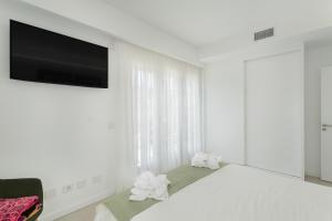 1 dormitorio blanco con 1 cama grande y TV de pantalla plana en Teresita La Fuente, en Puerto de Mogán
