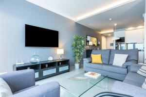 ein Wohnzimmer mit Sofa und Fernseher in der Unterkunft Teresita Mogamar Beachfront in Puerto de Mogán