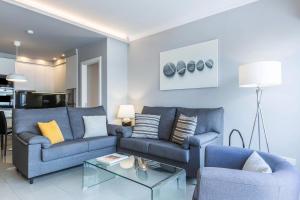 ein Wohnzimmer mit zwei blauen Sofas und einem Tisch in der Unterkunft Teresita Mogamar Beachfront in Puerto de Mogán