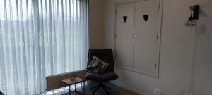 a black chair in a room with a window at Mooi Drenthe in Wezuperbrug +29 photos