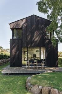a black house with tables and chairs on a deck at WIECKin in Wieck