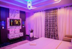 Camera viola con letto e TV di Skyrock Hotels Ikeja a Ikeja
