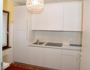a kitchen with white cabinets and a sink at Break Affittacamere in San Vito al Tagliamento