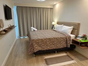 Una habitación de hotel con una cama y una ventana. en OCEAN FRONT luxury hotel room "Pacific Point", en Jacó