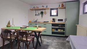 a kitchen with green cabinets and a table and chairs at Chalet Dor de Munte in Predeal