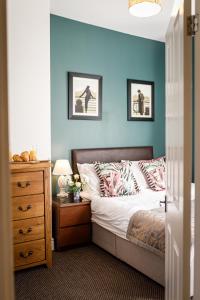 ein Schlafzimmer mit einem Bett mit einer blauen Wand in der Unterkunft Bright and Well-Kept 3-Bed Property! Free Parking in Bishop Auckland