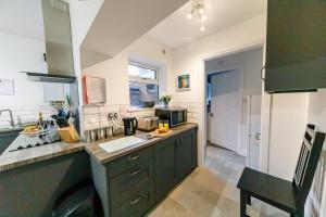 a kitchen with green cabinets and a counter top at Bright and Well-Kept 3-Bed Property! Free Parking in Bishop Auckland