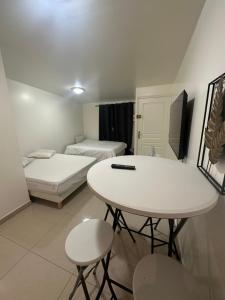 Habitación pequeña con 2 camas, mesa y sillas en Appartement beau livry, en Livry-Gargan