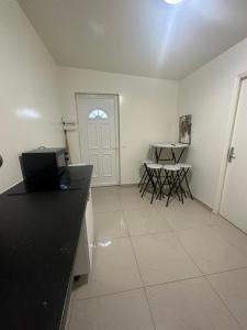 cocina con encimera negra, mesa y sillas en Appartement beau livry, en Livry-Gargan 10 fotos más