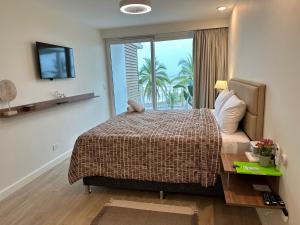 Un dormitorio con una cama y un televisor y una ventana. en OCEAN FRONT luxury hotel room "Pacific Point", en Jacó 37 fotos más