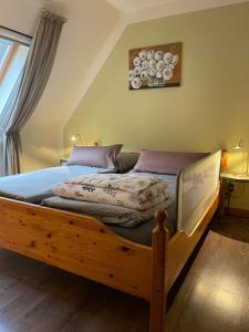 a bed with a wooden frame in a bedroom at Loh Apartments - Wald.Natur.Ruhe. in Undeloh