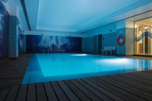 a swimming pool in a building with blue lighting at VIP Executive Azores Hotel in Ponta Delgada