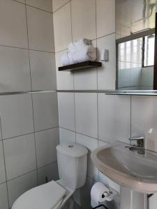 Un baño blanco con inodoro y lavabo. en Bello monoambiente en pleno prado cochabambino, en Cochabamba