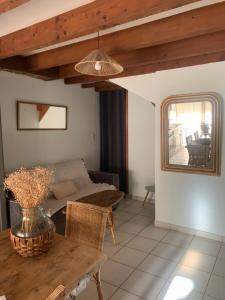 a living room with a table and a couch at Maison des glycines au bord du Doubs in Verdun-sur-le-Doubs