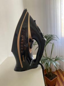 a iron sitting on a table next to a plant at Hastoci House in Lido di Ostia
