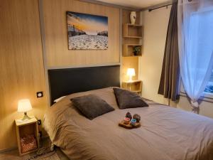 a bedroom with a bed with two teddy bears on it at La cabane 27 ~ Chalet cosy au bord du lac de Peyre in Labouheyre +23 photos
