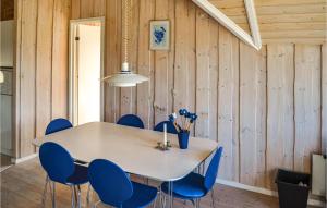 a dining room with a table and blue chairs at Holiday Home Slettevej Ii in Skagen