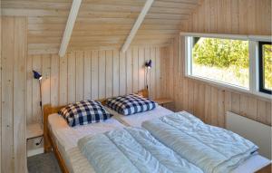 a bedroom with two beds in a wooden cabin at Holiday Home Slettevej Ii in Skagen +3 photos