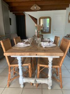 a wooden table with chairs and a dining room at Maison des glycines au bord du Doubs in Verdun-sur-le-Doubs +13 photos