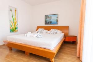 a bedroom with a large bed with white sheets at Holiday house Rogoznica in Podglavica