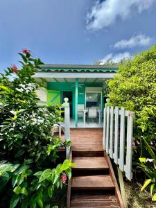 a house with a wooden staircase leading to a house at Alpinia bungalow in Sainte-Anne