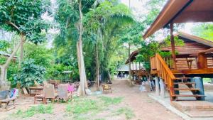 een resort met stoelen, tafels en bomen bij Cocoa Home in Ban Ko Phrao