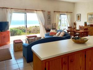 a living room with a view of the ocean at Beach Haven Cottage in Britannia Bay