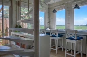 a spiral staircase in a room with chairs and windows at Artistiek Vakantiehuisje in Hulst