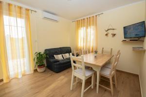 a living room with a table and a couch at Apartman Doris in Milohnići