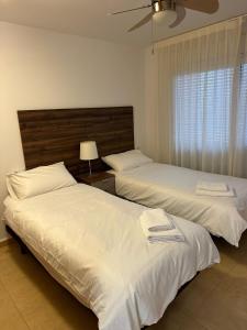 a bedroom with two beds and a window at Mar Menor Golf Resort 2 Bed Apartment in Los Martínez +18 photos