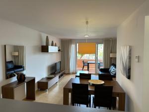 a living room with a table and a dining room at Mar Menor Golf Resort 2 Bed Apartment in Los Martínez