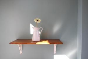 a vase with a flower on a wooden shelf at Moulins de Clan in Jaunay-Clan