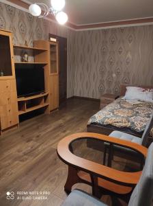 ein Zimmer mit einem Bett, einem Fernseher und einem Tisch in der Unterkunft VadMar in Tallinn