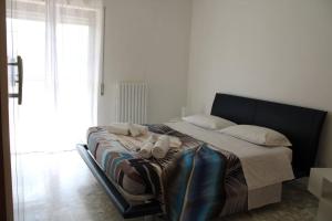 a bed in a white room with shoes on it at Belvedere da Madia in Monopoli
