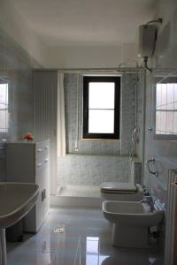 a bathroom with a sink and a toilet and a window at Belvedere da Madia in Monopoli