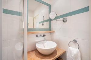 Un baño con un lavabo blanco y un espejo. en Ferienwohnung Waves, en Travemünde 17 fotos más