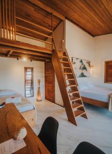 a bedroom with two beds and a spiral staircase at Casa Amado Atins in Atins