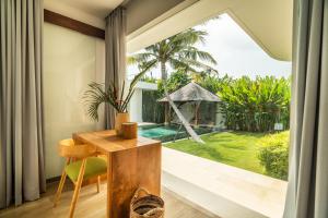 a room with a desk and a view of a pool at Exclusive 4BR Tranquil Sanctuary in Pererenan in Canggu