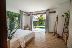 a bedroom with a bed and a view of a pool at Exclusive 4BR Tranquil Sanctuary in Pererenan in Canggu