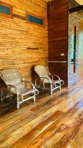two wicker chairs sitting in the corner of a room at Cocoa Home in Ban Ko Phrao