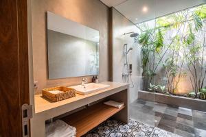a bathroom with a sink and a shower with plants at Exclusive 4BR Tranquil Sanctuary in Pererenan in Canggu +49 photos