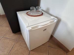 a white refrigerator with two glasses on top of it at Locanda da Marì in Aulla