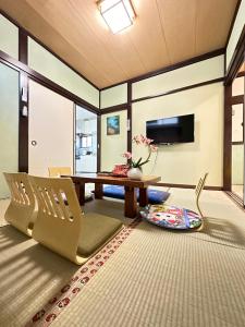 ein Wohnzimmer mit einem Tisch und einem Stuhl in der Unterkunft 青砥駅徒步5分 Aoto だるま宿 in Tokio