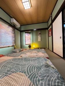 ein Schlafzimmer mit zwei Betten in einem Zimmer in der Unterkunft 青砥駅徒步5分 Aoto だるま宿 in Tokio