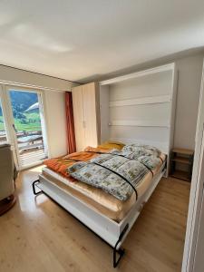 a bedroom with a bed and a large window at Utoring 322 in Leukerbad