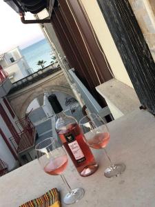 トッレ・カンネにあるEmma's House by IL PUMO DI PUGLIAの海の景色を望むテーブルの上にワイン2杯