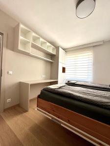 a bedroom with a bed and a desk and a window at Royal Retreat - sarac Apartment in Bad Ischl