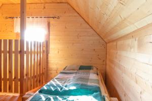 a small room with a bed in a wooden cabin at Waldhütte Stifthube in Obertal