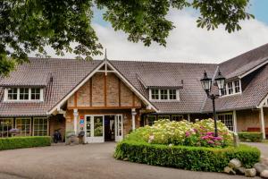 an old building with a house at Landhuishotel De Bloemenbeek in De Lutte
